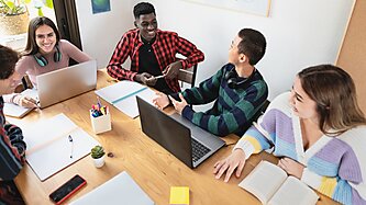 Group of students at a desk laughing