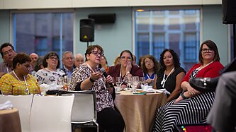 Woman in audience with microphone asking a question